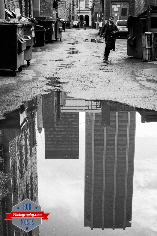 Downtown Calgary Alley puddle city reflection guy man street - Rob Moses Photography - Photographer famous 50L