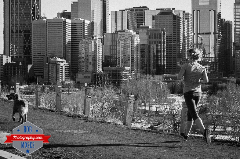 Woman girl run running jogging dog doggy Calgary Alberta Canada YYC Skyline urban metro buildings - Rob Moses Photography - Vancouver Seattle Photographer - Famous Pentax 50mm - Street Photographers Path Trail-1