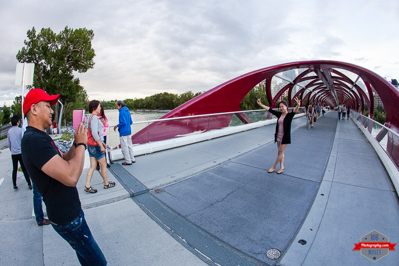 YYC woman man Peace Bridge fisheye uran modern people street picture phone - Rob Moses Photography - Vancouver Seattle Calgary Photographer Photographer Native American Famous Tlingit Ojibawa Top Popular Best Canadian Lifestyle